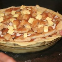 Dotting the pear pie with butter before baking