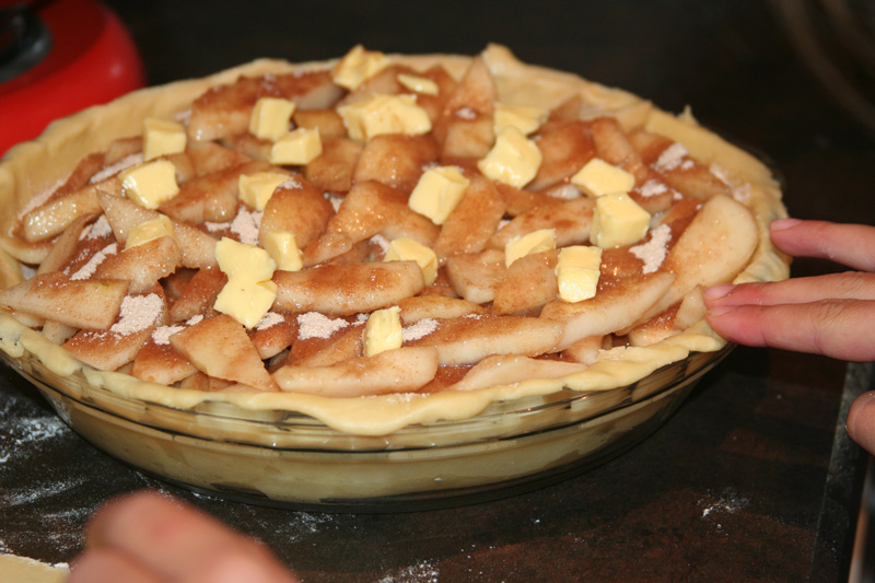 Dotting the pear pie with butter before baking
