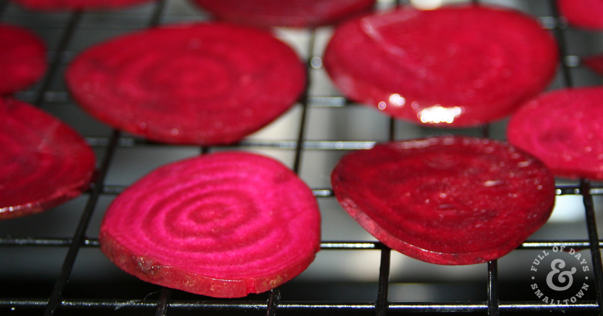 Sliced beets in a dehydrator for homemade beet chips.