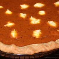 Close up of cream cheese pumpkin pie on a cooling rack.