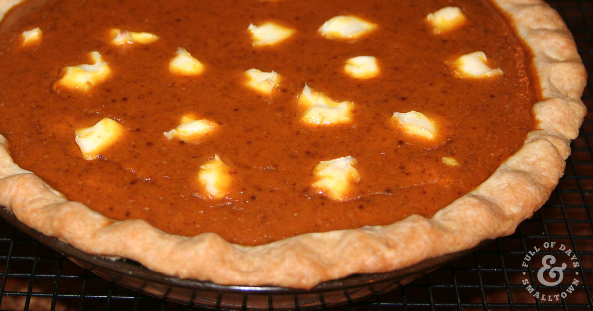 Close up of cream cheese pumpkin pie on a cooling rack.