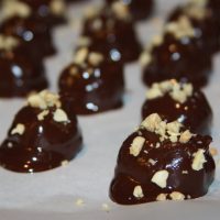 Dippy Do's topped with crushed peanuts lined up on parchment paper.