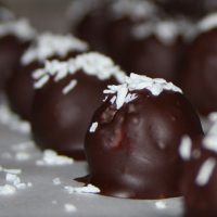 Chocolate Covered Coconut Candies with Coconut flakes on top.