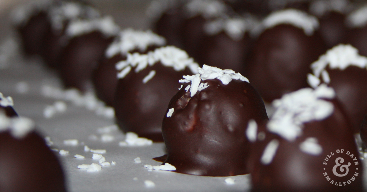 Chocolate Covered Coconut Candies with Coconut flakes on top.