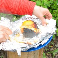 Sourdough Orange Cake just out of the fire. Cake batter is in the orange peel, then wrapped in tinfoil.