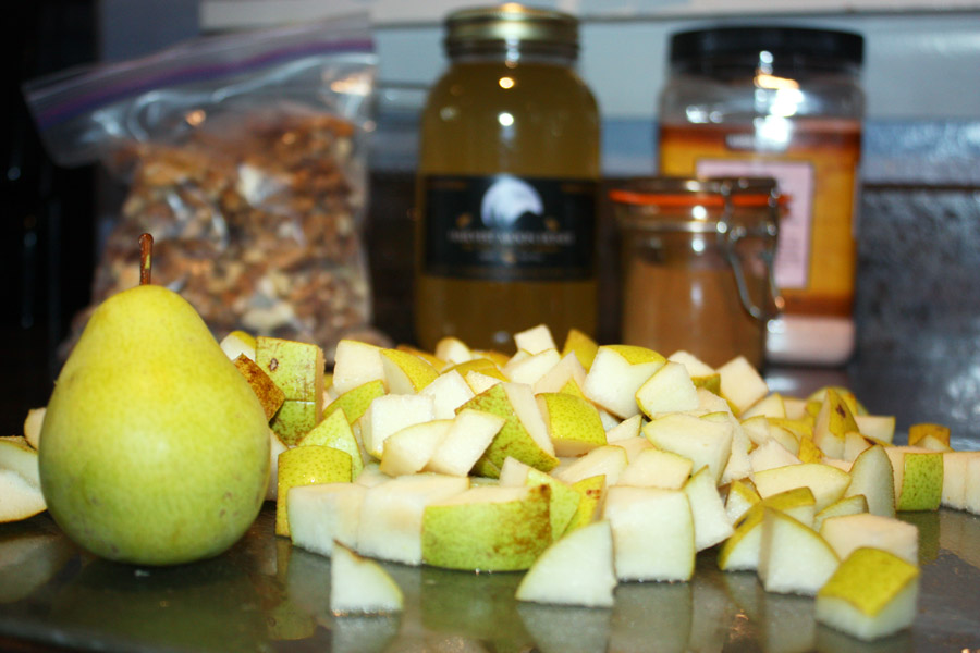 Chopped pears with ingredients for cashew walnut pear crisp in background