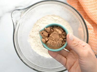 Mixing cocoa powder into the dry ingredients in a mixing bowl for healthy homemade oreos.