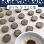 Little chocolate cookies dipped in sugar on a parchment lined cookie sheet. Text overlay say, "Healthy Homemade Oreos with Dairy-Free Icing".